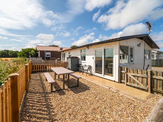 An outdoor area with a table and chairs at Bay View Chalet 2 Bed Sleeps 4 Pets Garden Beach Wilsthorpe near Bridlington