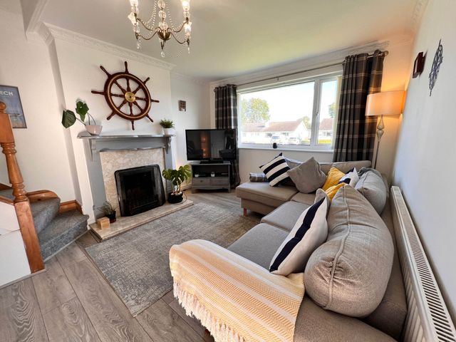A living room with a sofa and television at 2 Bed Family Bungalow, WiFi, Parking, Garden, Dogs Pentraeth