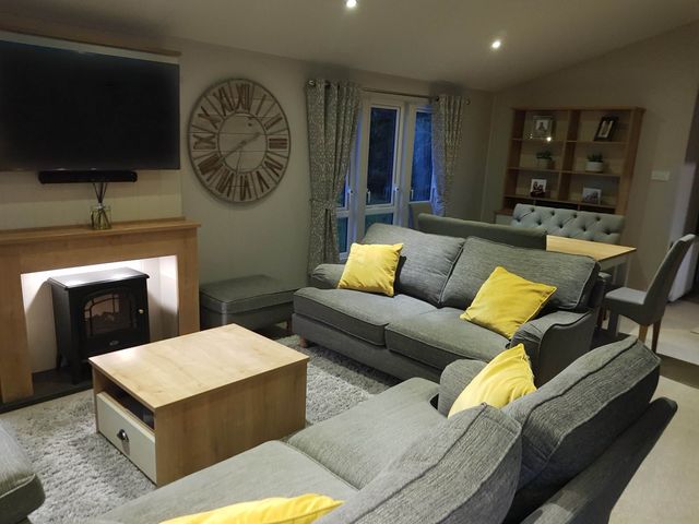 A living room with a sofa and television at Cayton Bay Lodge Parkdean Resorts, Scarborough