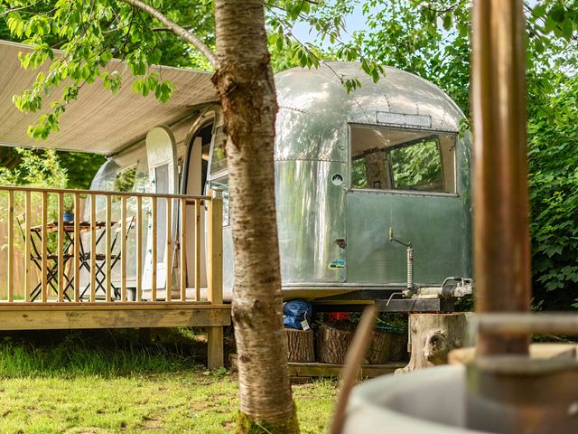 A trailer with a deck and table at Sleeps 2 - Private Hot Tub - Fire Pit in St. Dogmaels near Cardigan