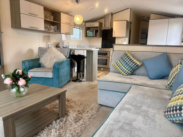 A living room with a sofa and a coffee table at Caravan in Holcot Sleeps 6 Max 6 people Max 4 adults per booking Pet Friendly Holcot near Moulton