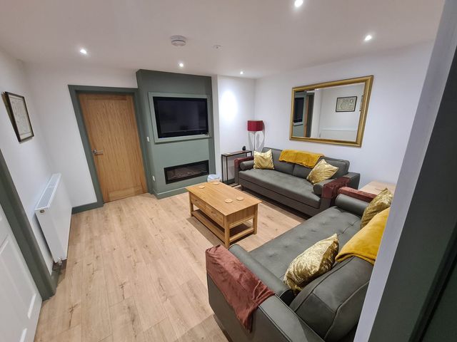 A living room with a television and sofas at Conwy Charm Cottage 3 Bed Retreat Penmaenmawr