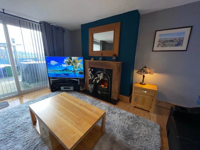A living room with a television and a fireplace at Tanygrisiau near Blaenau Ffestiniog