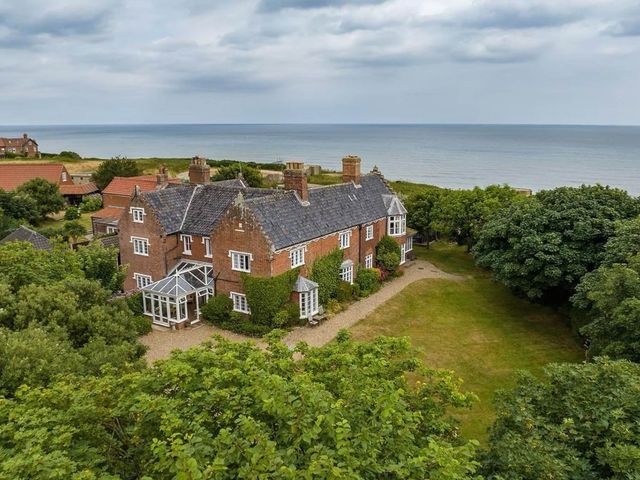 An outdoor view of a house near the ocean at Norfolk Seaview Luxury Retreat with 7 Bedrooms in Mundesley
