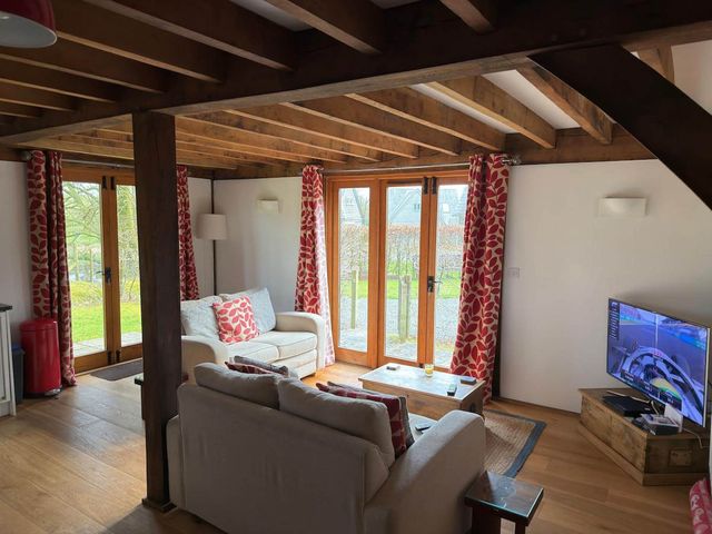A living room with a sofa and television at Tremail near Camelford