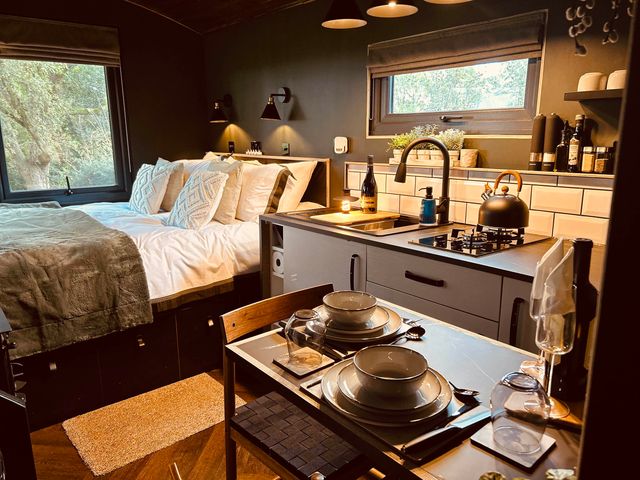 A bedroom with a kitchen area and dining table at The Old Barn in Newton Abbot