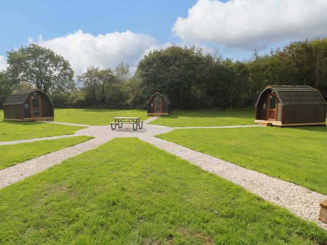 An outdoor area with cabins and a picnic table at Goldfinch Pod Swannington near Coalville