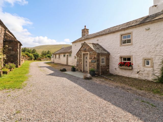 An outdoor view of a cottage with a gravel path at Claybottom Farm in Hesket Newmarket