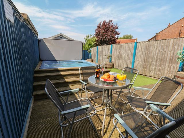 An outdoor area with a hot tub and seating at The Cosy Haven in Malton
