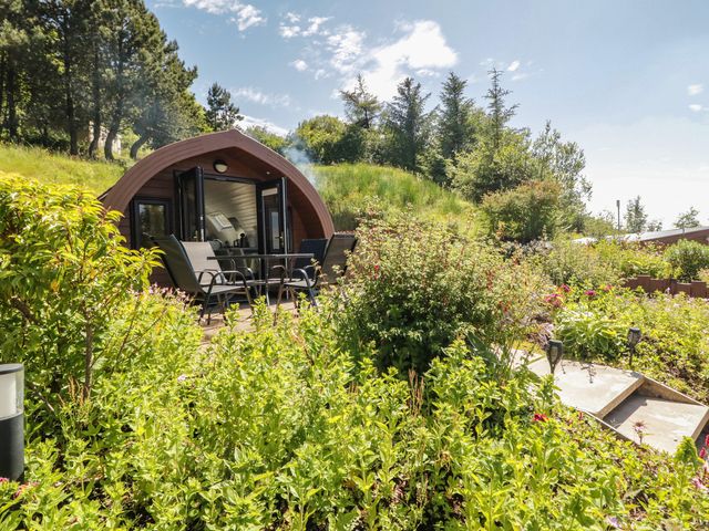 A glamping pod with chairs and table surrounded by garden at Gortin Glen Glamping Pod 3, Omagh