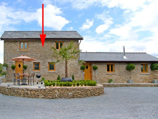 A stone house with windows and a garden table at Valley View in Ross-on-Wye