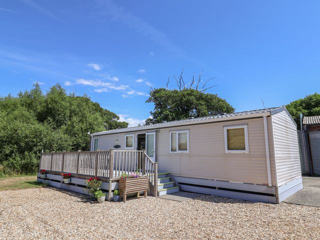A mobile home with a deck and steps at The Hideaway in Portesham