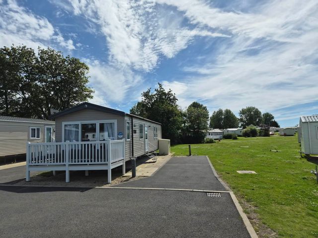 A mobile home with a deck and driveway at Marton mere Westminster Blackpool