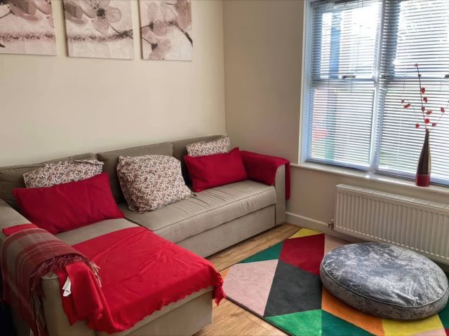 A living room with a sofa and cushions at Admirals Rest in Weymouth