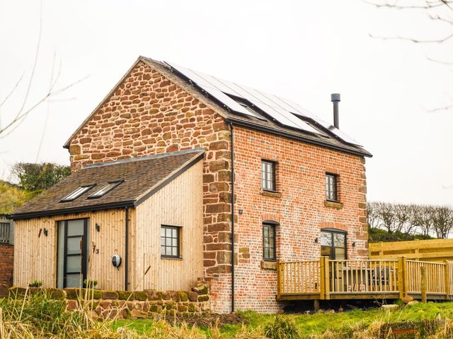 A house with solar panels and wooden decking at The Old Mill Great Bolas near Telford