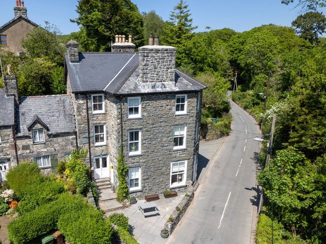 A house situated near a road surrounded by greenery at Gwynfryn House in Llanbedr