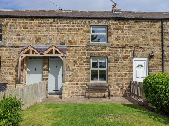 The exterior of a house with two entrances and a bench at Canny Cottage in Belford