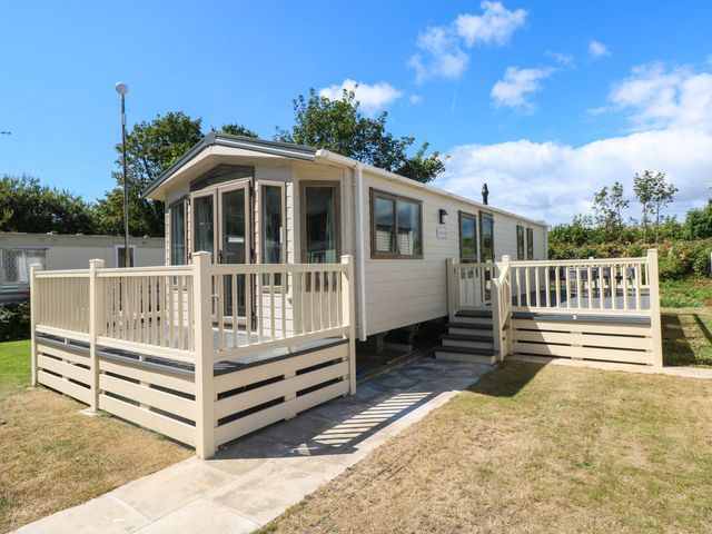 A mobile home with a deck and steps at Number 19 in Ferryside