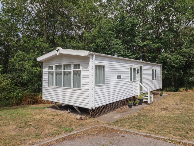 A mobile home with steps and plants at Plot 13A