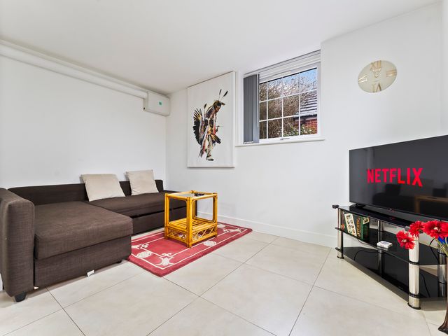 A living room with a sofa and television at 2 Pump House in Birmingham