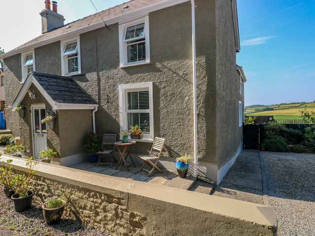 An outdoor seating area with a chair and table at St.Twynells Farm in Pembroke