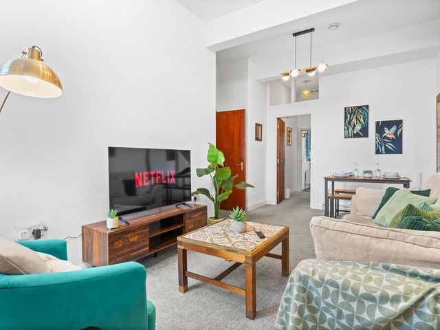 A living room with a television and seating area at The Gilder Birmingham City Apartment Birmingham