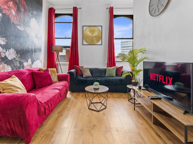 A living room with a sofa and television at The Goldsmith Birmingham City Apartment Birmingham