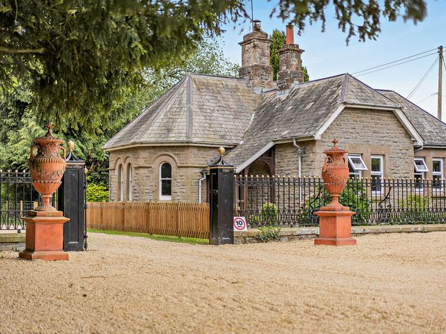 A house with a fence and ornamental urns at Gate House in Leominster