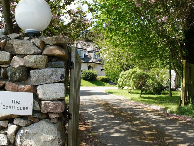 A driveway leading to a house with a stone wall at The Boathouse in Aberdeen