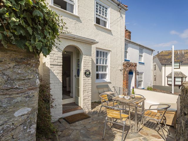 An outdoor seating area with a table and chairs at Primrose Cottage in Salcombe