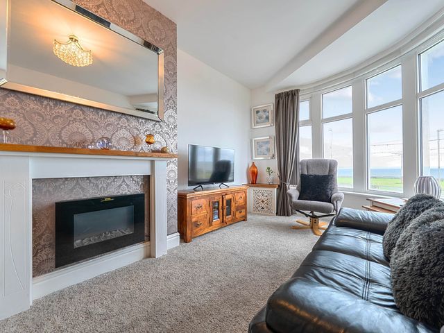 A living room with a sofa and television at The Old Barn in Bispham