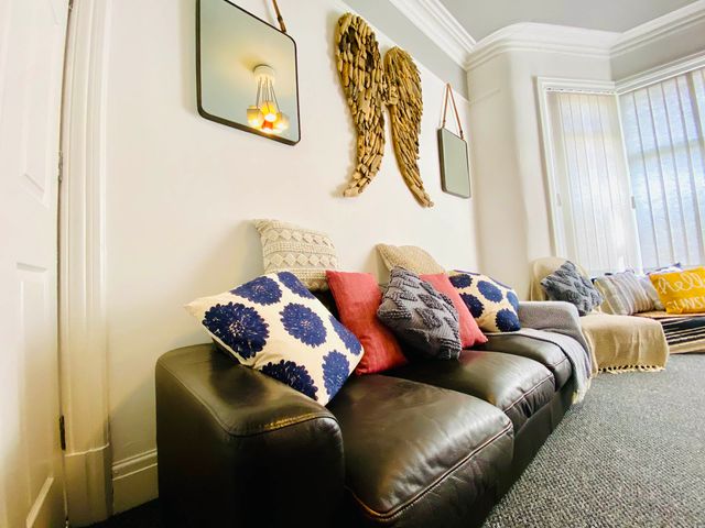 A living room with a sofa and decorative pillows at Blackpool 4 Beds Sleeps 10 Pet Friendly, Blackpool