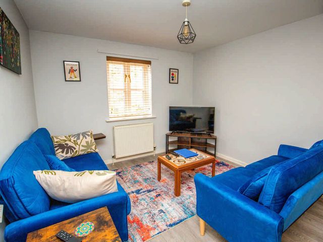 A living room with a TV and blue sofas at House Sleeps 4 with Parking and Garden in Glastonbury