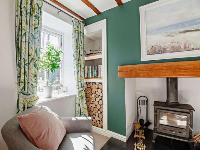A living room with a fireplace and bookshelves at Cottage Sleeps 5 with Parking and Garden in Carreglefn