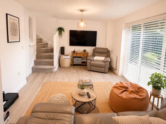 A living room with a tv and armchair at The Old Barn in Manchester
