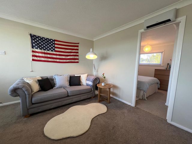 A living room with a flag on the wall and a sofa at The Old Barn in Manchester