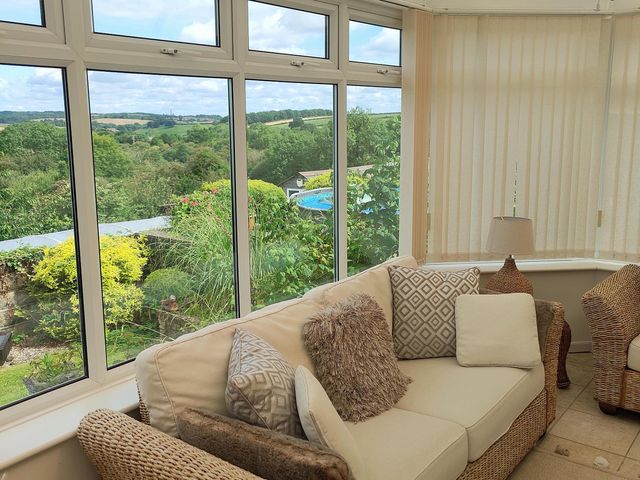 A conservatory with a sofa and lamp at Split Level Bungalow Sleeps4 Close to walks Stanton Hill