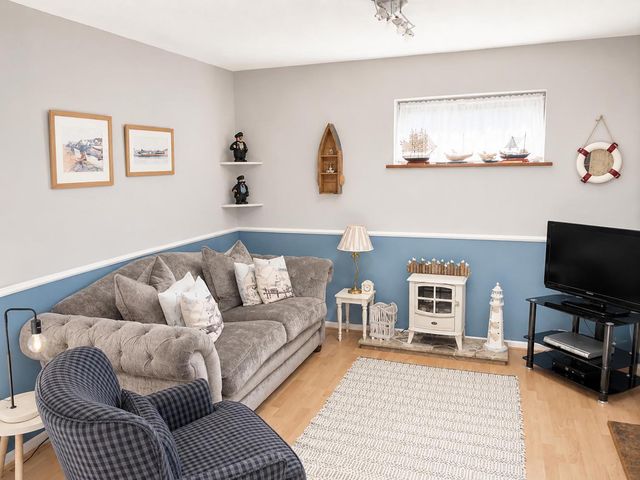 A living room with a sofa and a television at Coastal Chalet Retreat in St Margaret's Bay
