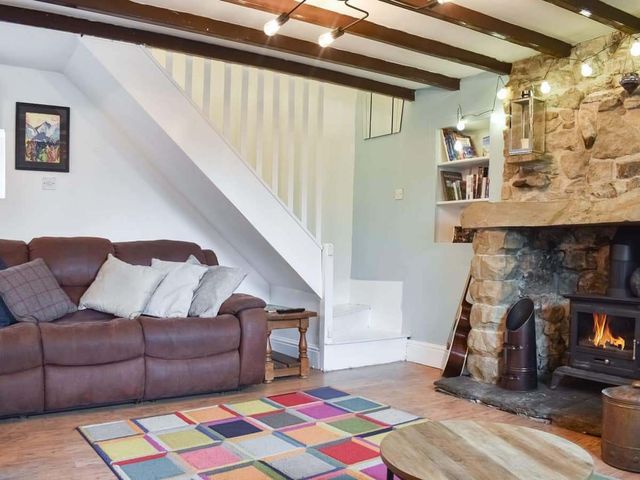 A living room with a couch and a fireplace at The Old Barn in Manchester