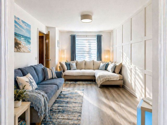 A living room with a sectional couch and wall art at The Old Barn in Manchester
