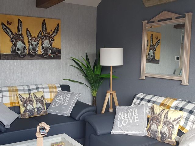A living room with sofa and cushions at The Old Barn in Manchester
