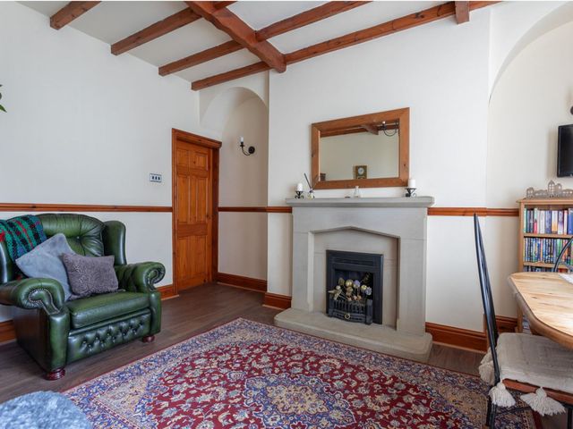 A living room with a fireplace and armchair at Haworth Village House Sleeps 6 Parking Pets in Cross Roads
