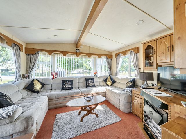 A living room with a sectional sofa and coffee table at 3 Bed Sleeps 8 Sea View Pets Parking Reighton Gap near Filey