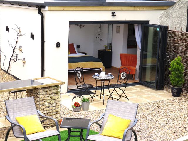 An outdoor seating area with chairs and a table at The Old Barn in Manchester