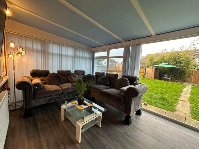 A conservatory with sofas and a coffee table at 4 Bed House Sleeps 8 Pets Parking Wifi