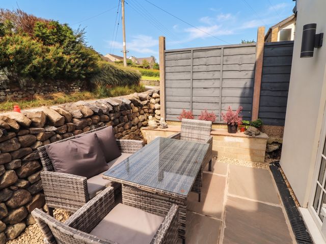 A garden seating area with a stone wall and plants at Fourways in 