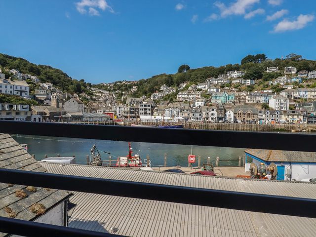 A view of buildings and boats along a river at Harbourside Retreat in Looe