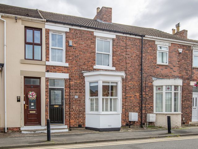 A row of houses with brick walls and various front doors at Hudson House
