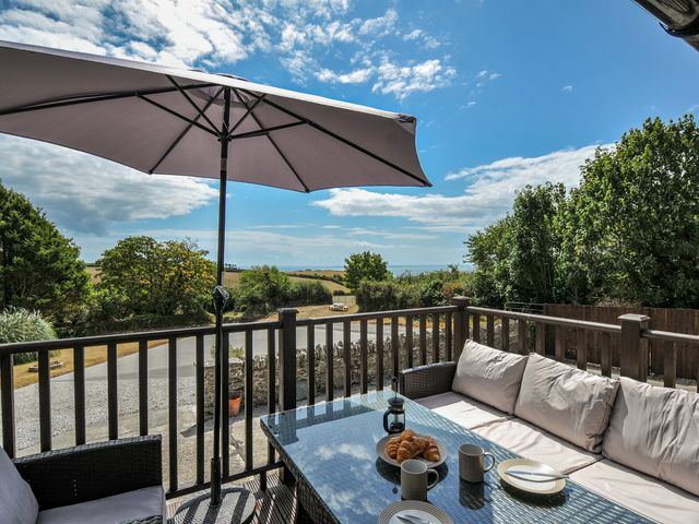 An outdoor seating area with a table and umbrella at The Old Wagon House in Torpoint