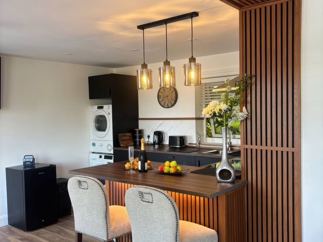 A kitchen with a bar counter and stools at Truly Scrumptious in Yarm